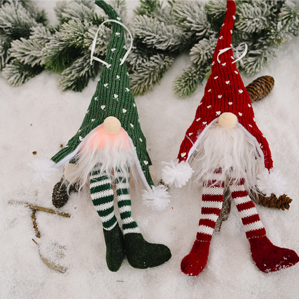 Knitted gnome ornaments in red and green with white hearts and striped legs.