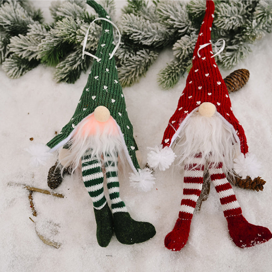 Knitted gnome ornaments in red and green with white hearts and striped legs.