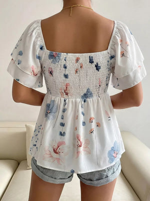 Smocked square neck blouse with flutter sleeves and a floral print.