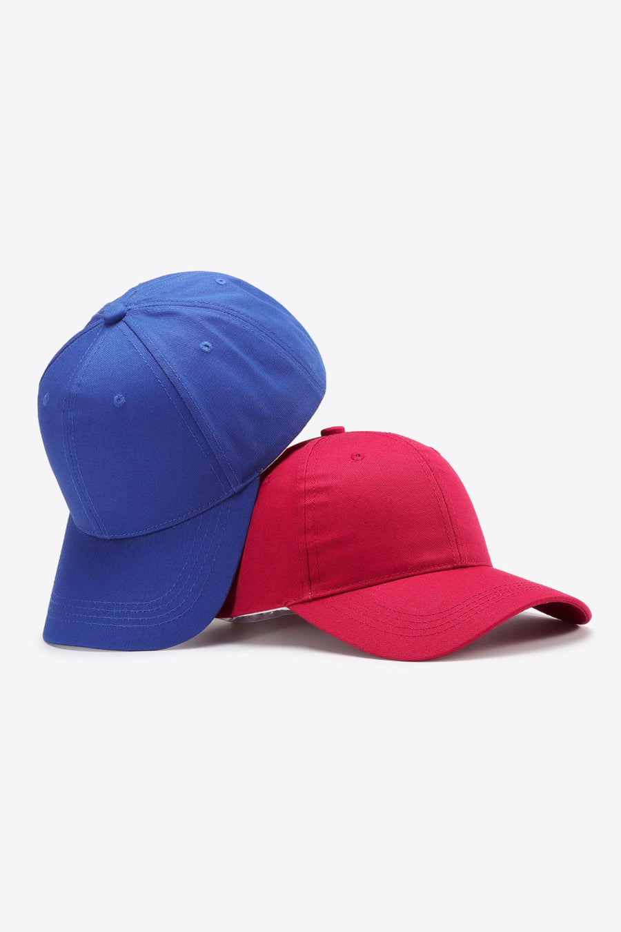 Royal blue and red cotton twill baseball caps shown stacked.