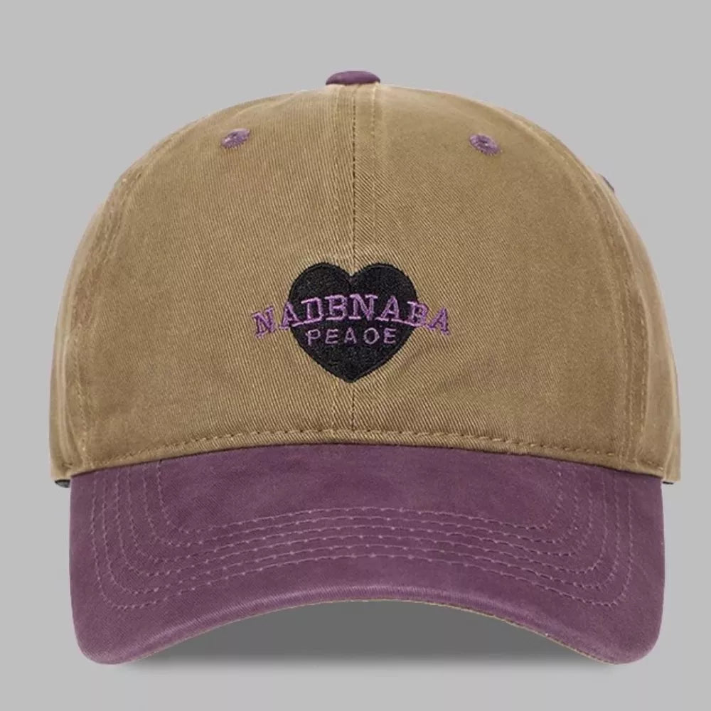 Tan and purple cotton baseball cap with embroidered heart detail and text.