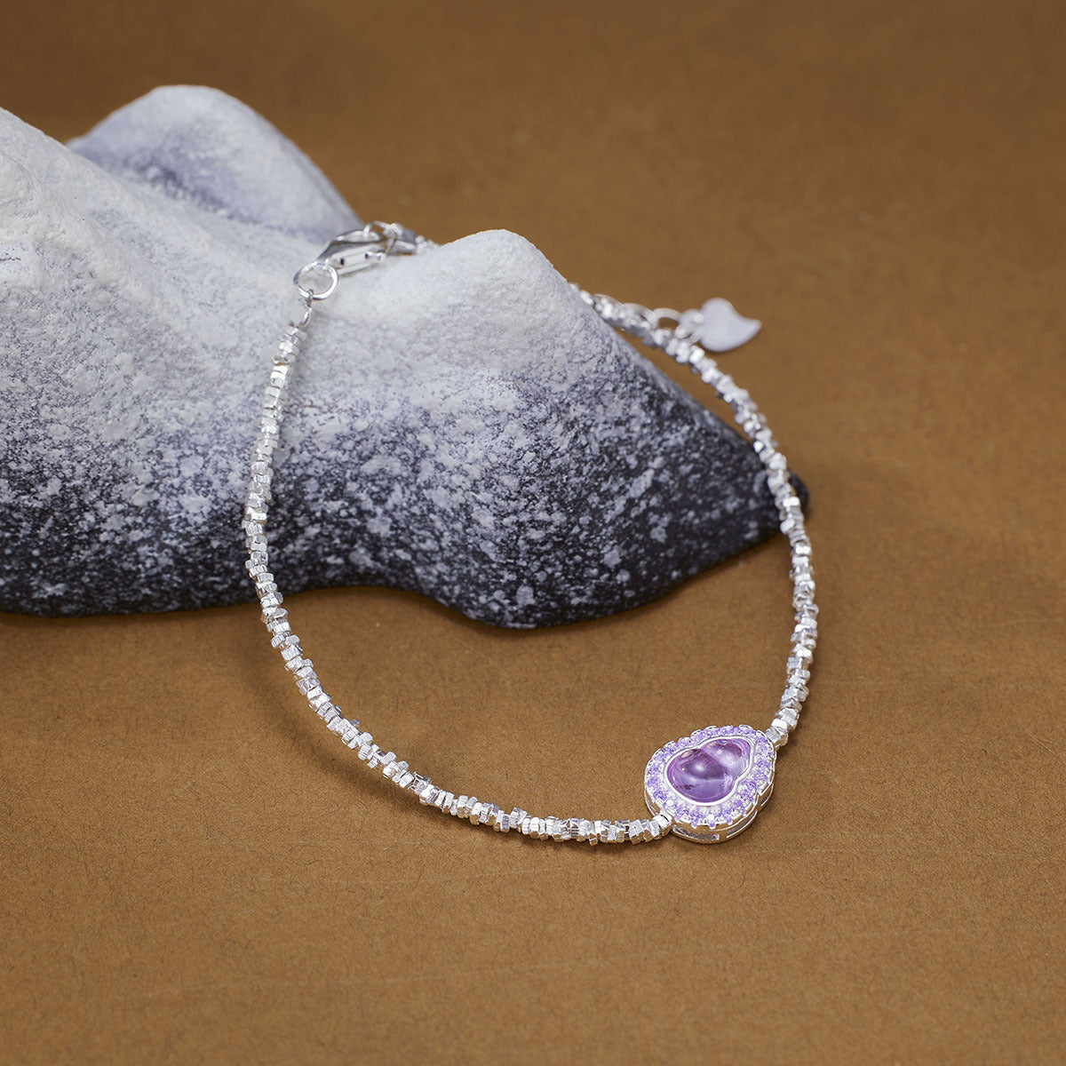 Delicate silver bracelet with a purple gourd charm and crystal accents.