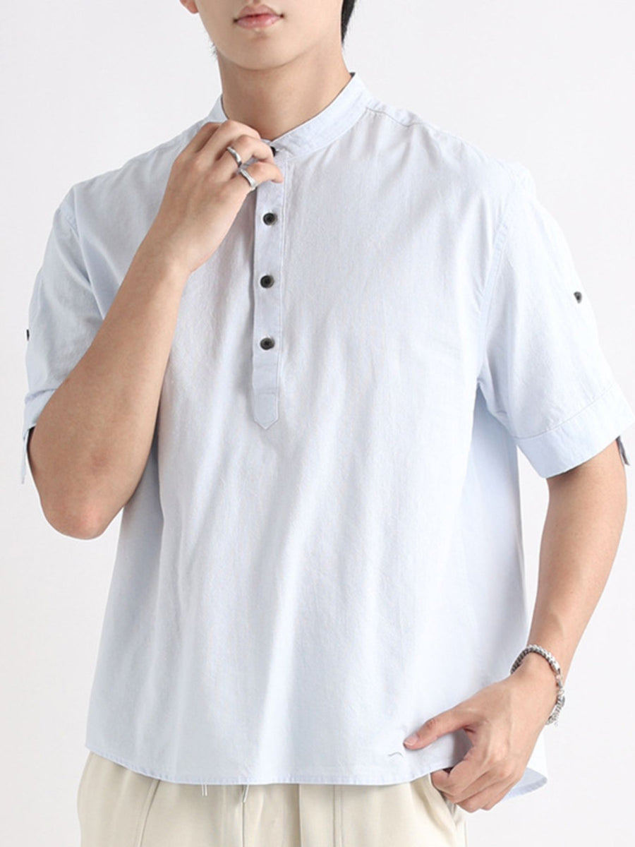 Men's light blue short sleeve band collar button-down shirt with dark buttons.