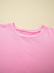 Pink cotton blend oversized tee with floral lace detail at the neckline.