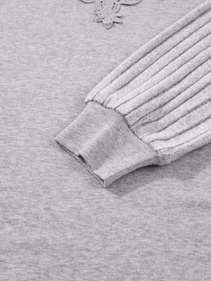 Gray ribbed knit long-sleeve top with lace detail at neckline and textured sleeves.
