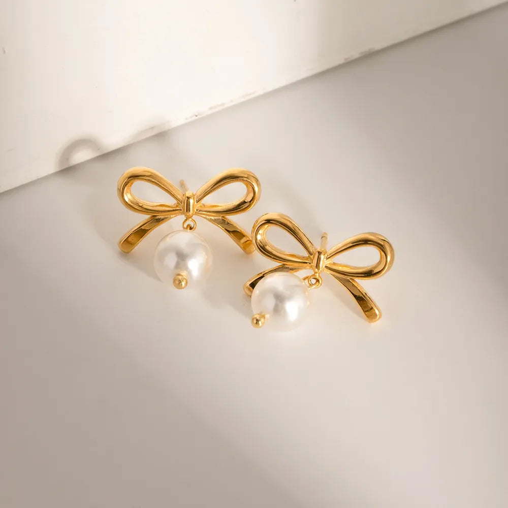 Gold bow drop earrings with pearl accents