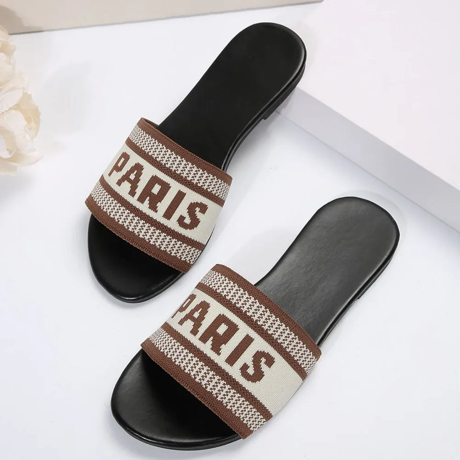 Parisian logo-band slide sandals in beige and brown with black soles.