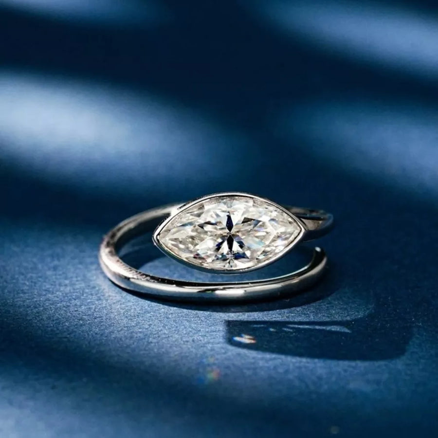 Elegant bypass ring with a large marquise moissanite stone in a silver setting.