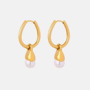 Gold oval hoop earrings with a pearl drop detail.