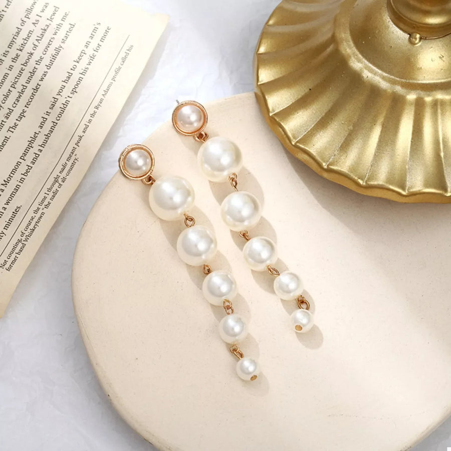 Elegant cascading pearl drop earrings in gold with multiple pearl sizes.