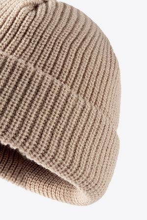 Beige ribbed knit beanie with a folded edge detail.