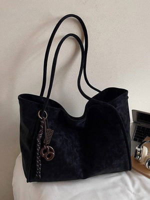Large black suede shoulder bag with braided rope and charm detail