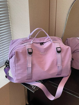 Purple nylon travel bag with buckle straps and adjustable shoulder strap
