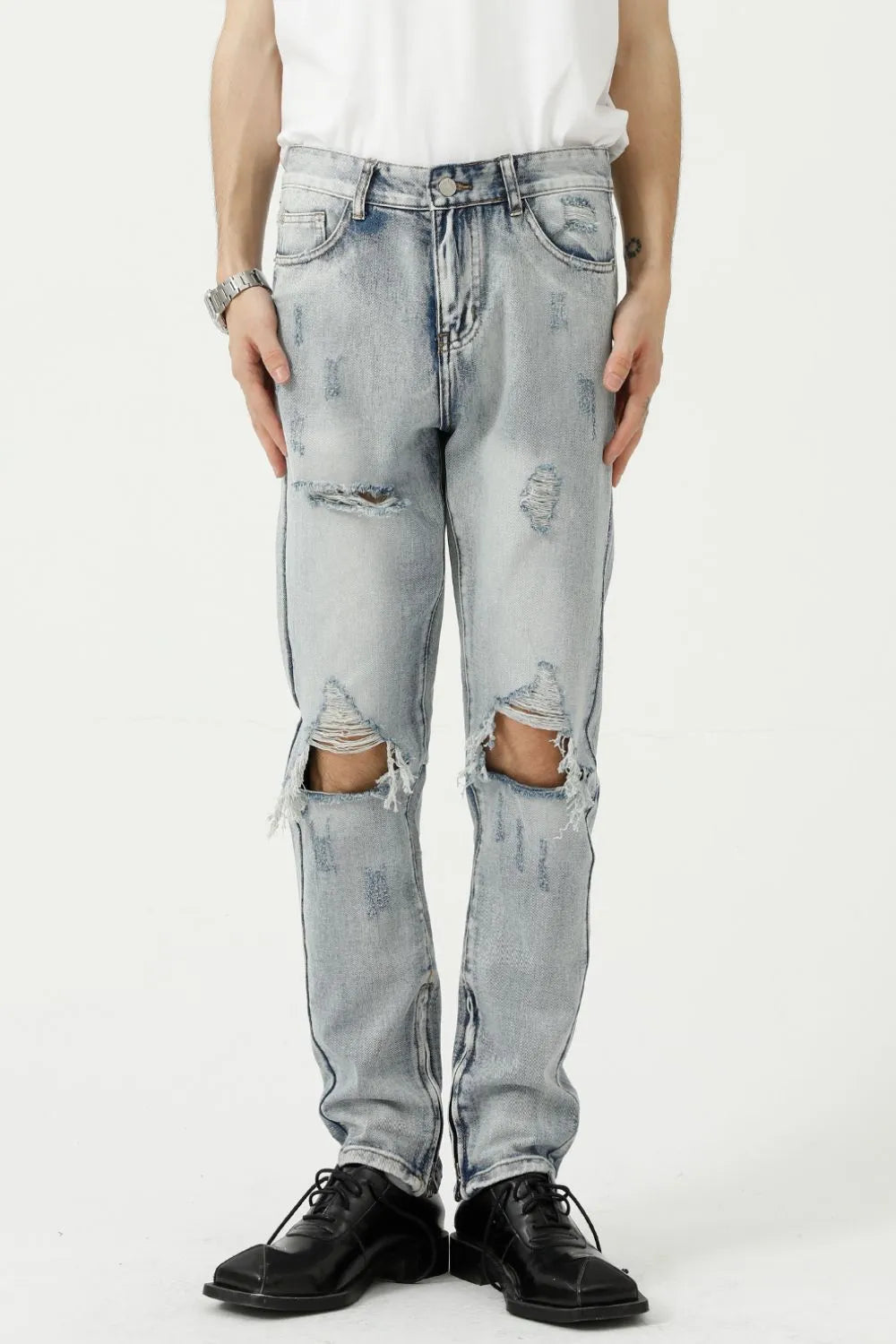 Light wash ripped knee slim fit denim jeans with distressed details.