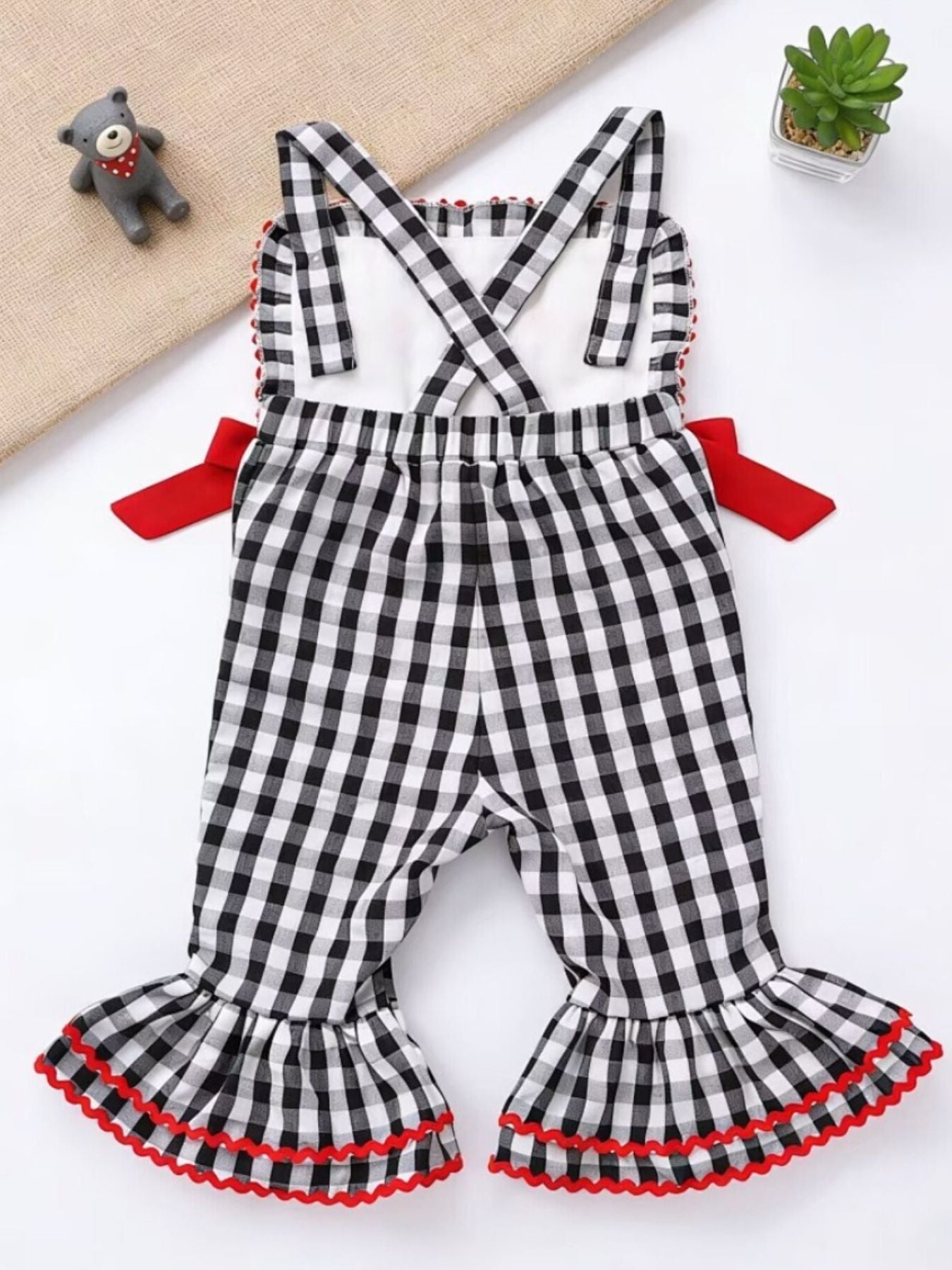 Baby bell bottom jumpsuit in black gingham with red trim and bows.