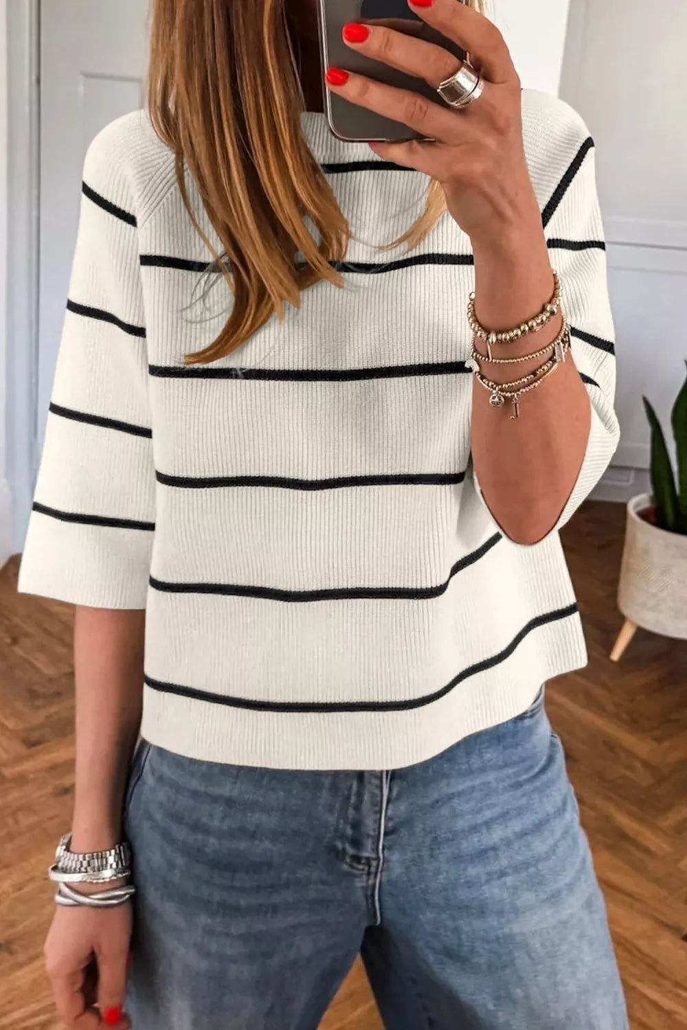 White ribbed knit top with black stripes and elbow-length sleeves.