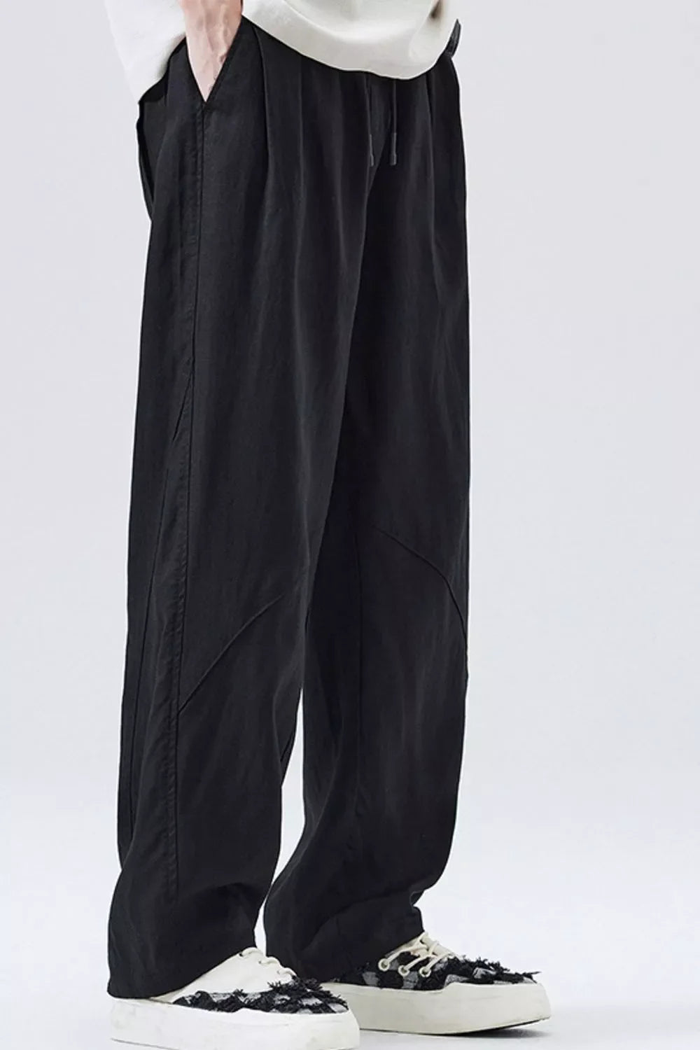 Loose fit black drawstring casual pants with a relaxed cut and subtle seam details.