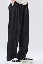 Loose fit black drawstring casual pants with a relaxed cut and subtle seam details.