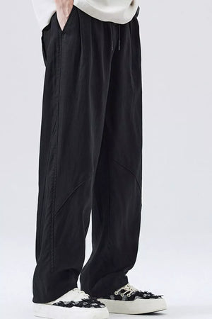 Loose fit black drawstring casual pants with a relaxed cut and subtle seam details.