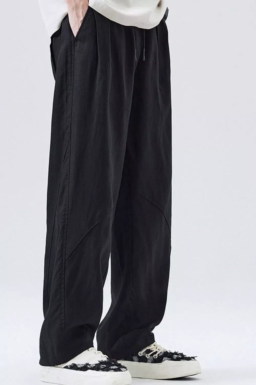 Loose fit black drawstring casual pants with a relaxed cut and subtle seam details.