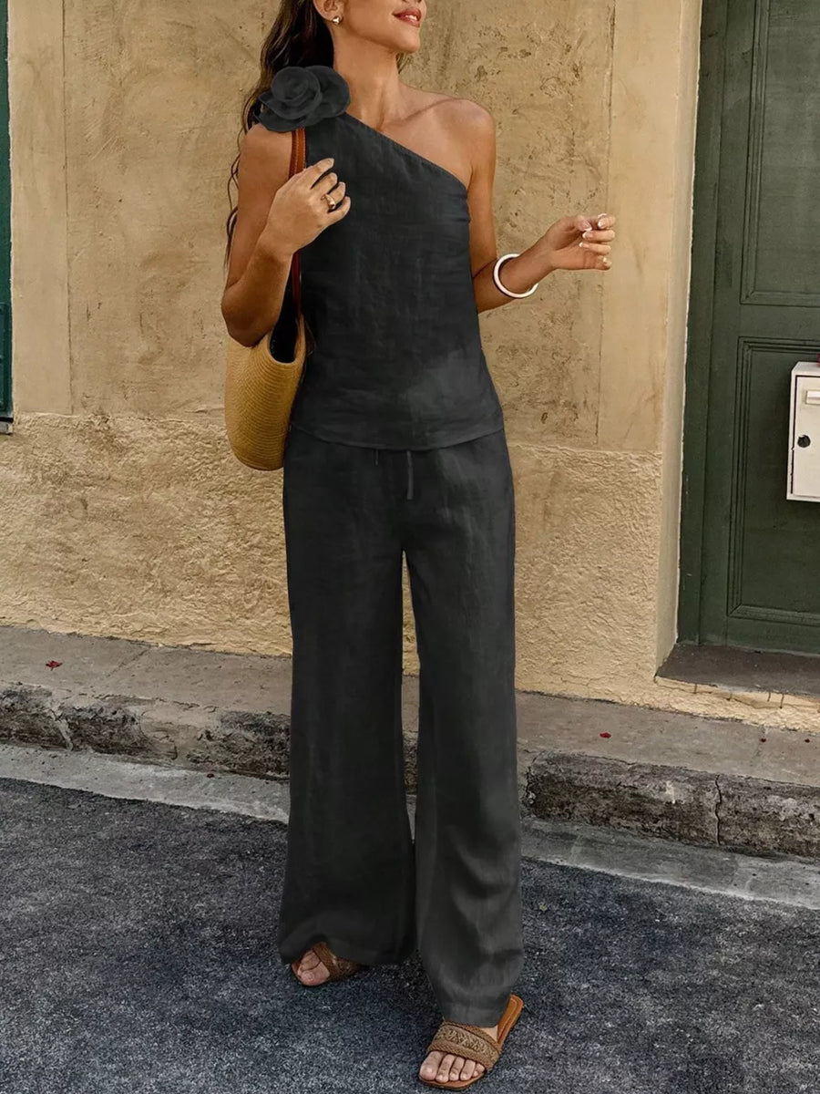 Black floral embellished one-shoulder top and wide-leg pants set with drawstring waist.