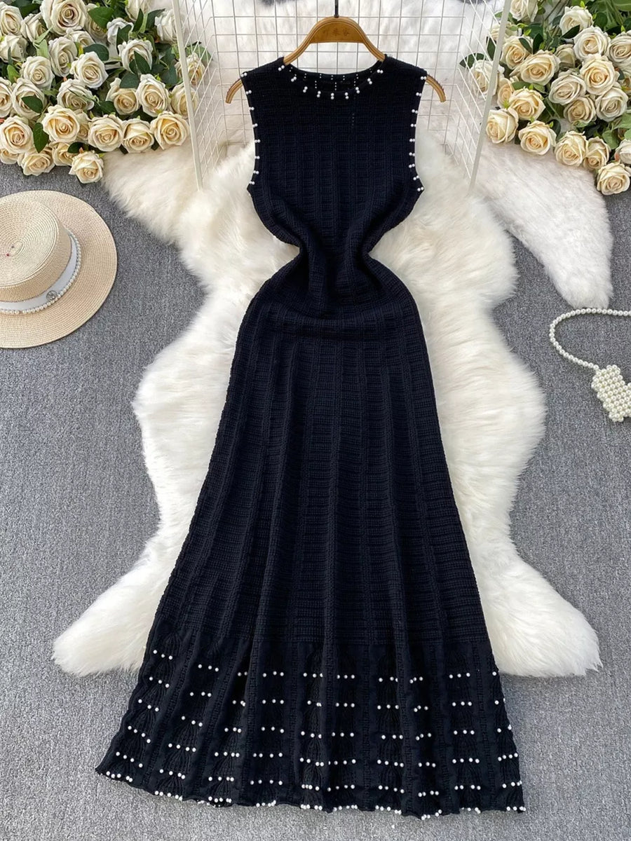 Black knit midi dress with pearl details at neckline, armholes, and hem.