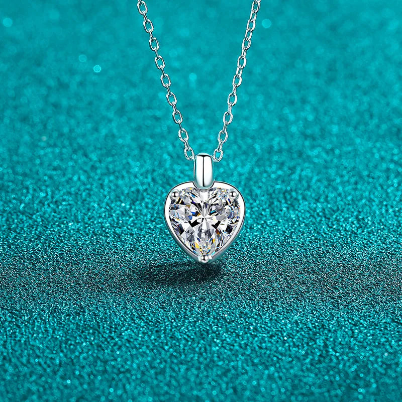Silver heart cut moissanite pendant necklace on a delicate chain.