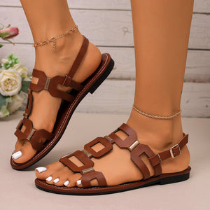 Brown cutout open-toe sandals with gold hardware detail and ankle strap.