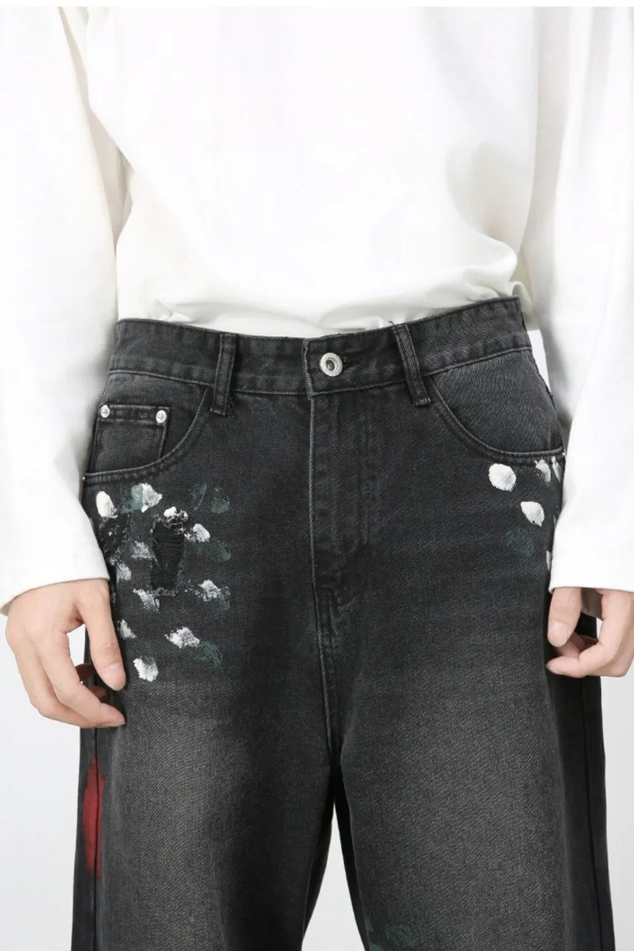 Dark wide-leg jeans with painterly white and green brushstrokes and distressed details.