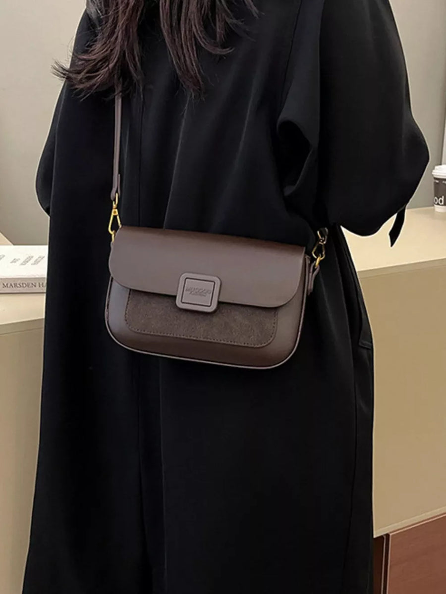 Chic two-tone crossbody bag in coffee brown with suede flap and gold hardware.