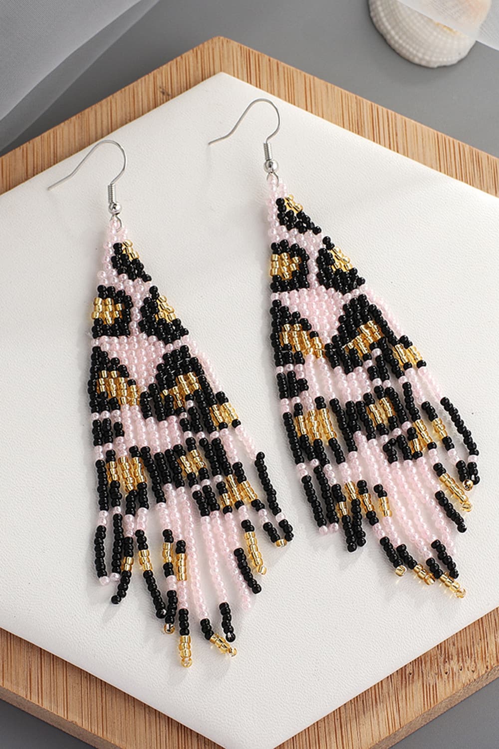 Blush pink beaded fringe earrings with leopard print detail and gold accents.