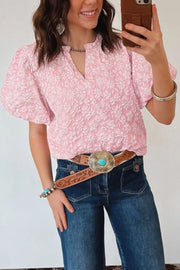 Textured floral puff sleeve shirt in blush pink with a V-neck and short sleeves.