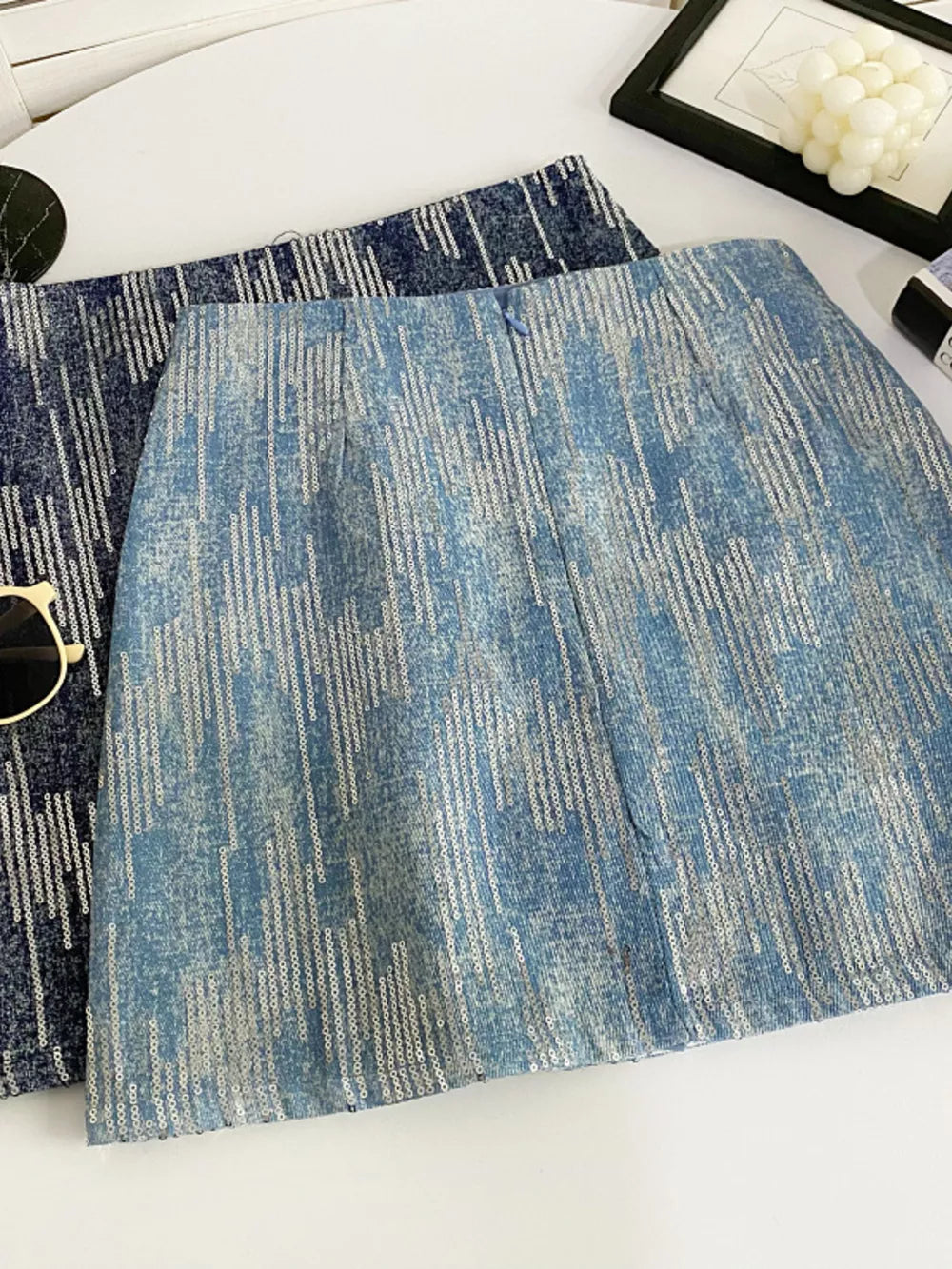 Light blue sequin mini skirt with vertical stripe pattern and zipper detail