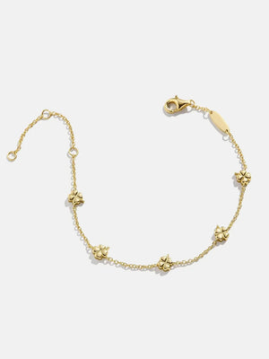 Gold chain bracelet with small four-leaf clover charms.