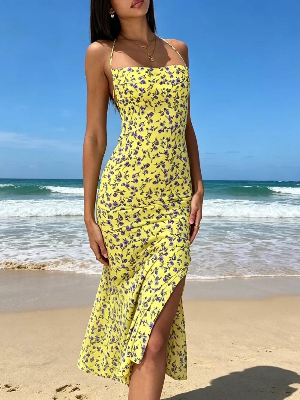 Yellow floral halter neck midi dress with backless detail and thigh-high slit.
