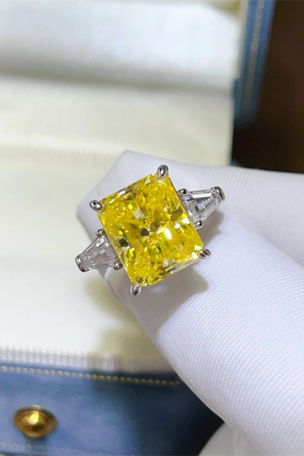Canary yellow emerald cut ring with side baguette diamonds.