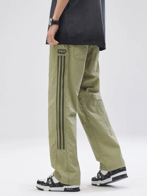Men's sage drawstring sweatpants with side stripe detail and patch.