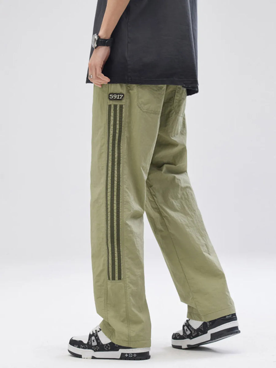 Men's sage drawstring sweatpants with side stripe detail and patch.
