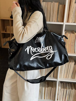 Sleek black PU leather travel bag with white script logo, shoulder strap, and top handles.