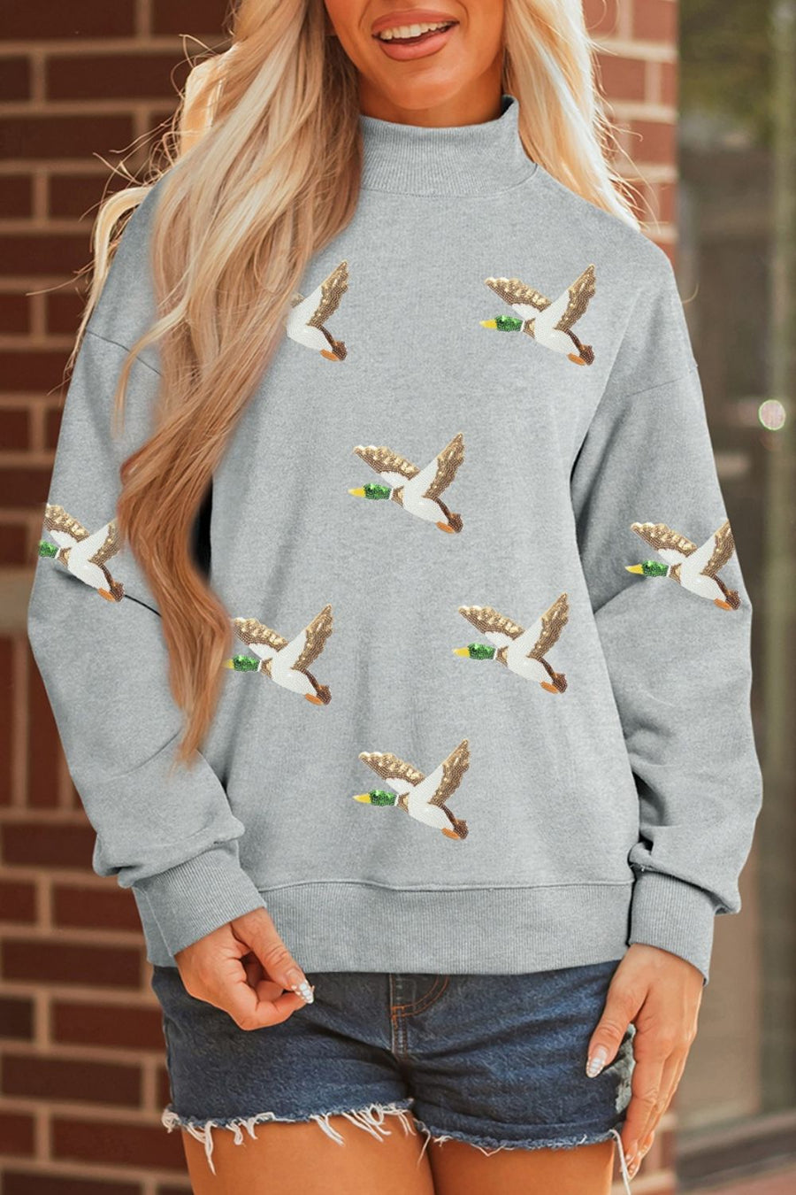 Gray sweatshirt featuring mock neck and graphic print