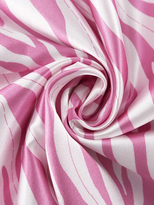 Satin fabric with pink and white zebra print, draped and swirled.
