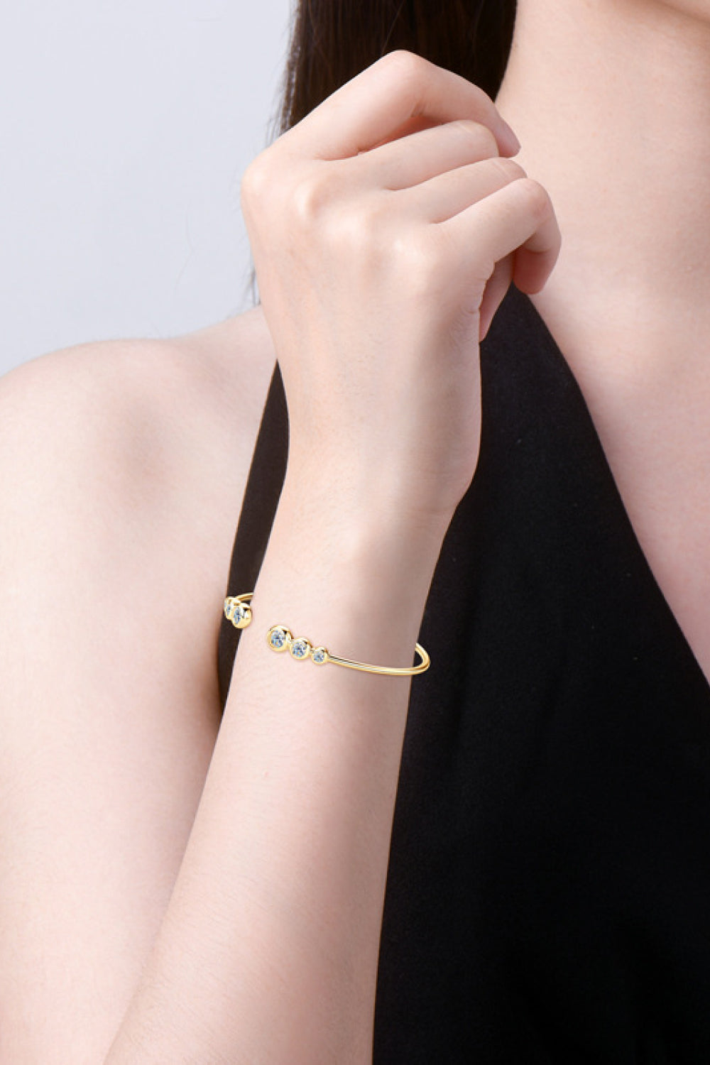 Gold open-ended cuff bracelet with five clear round stones