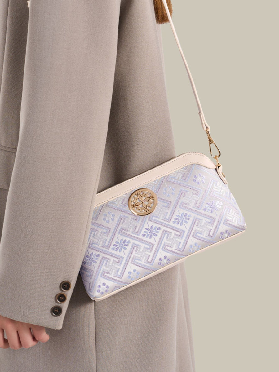 light blue crossbody bag featuring adjustable strap and geometric