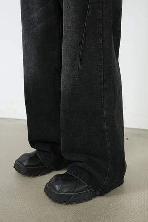 Oversized black wash denim jeans with a wide leg and visible stitching detail.