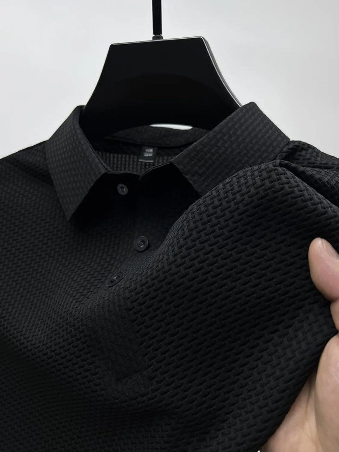 Black textured weave polo shirt with maxi collar and button placket.