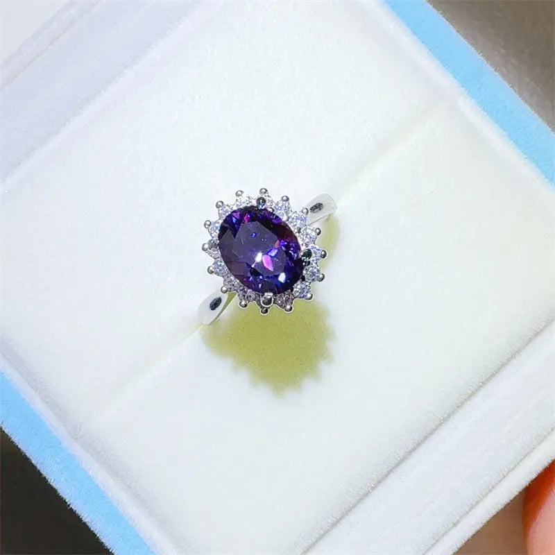 Silver ring with oval amethyst center stone surrounded by small clear stones.