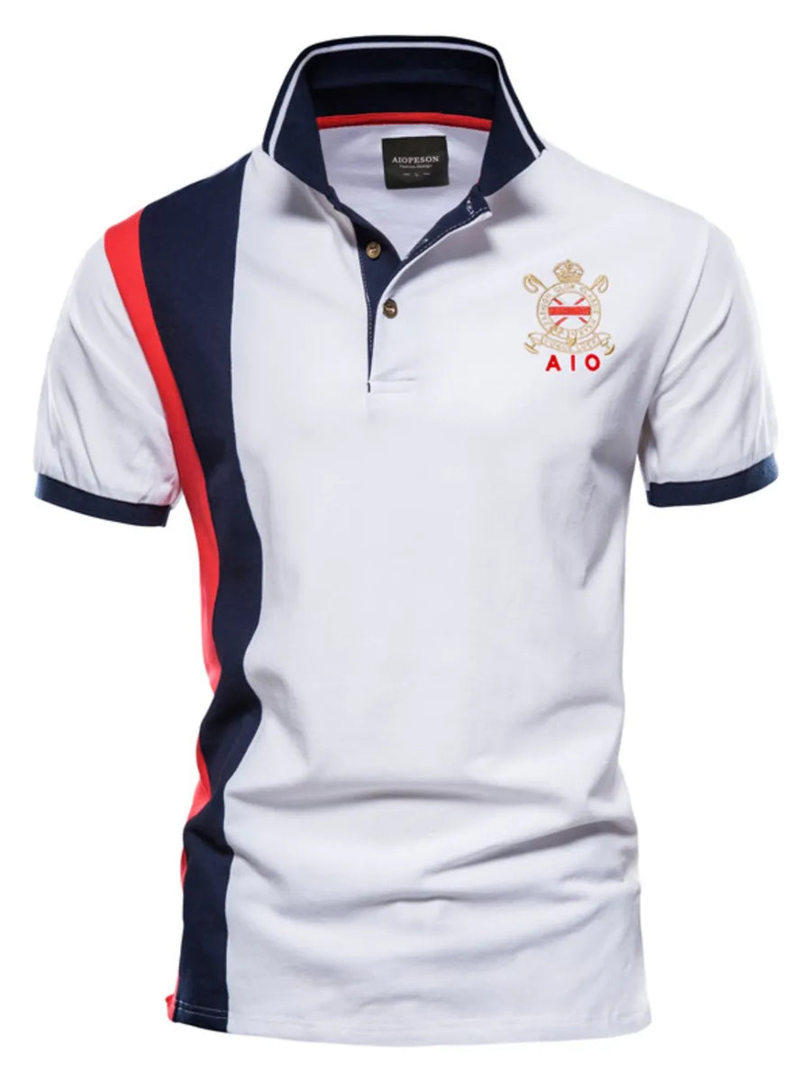 White polo shirt with navy and red colorblock sleeves and crest detail.