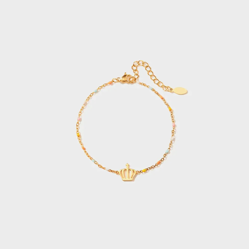 Gold bracelet with colorful enamel beads and a crown charm.