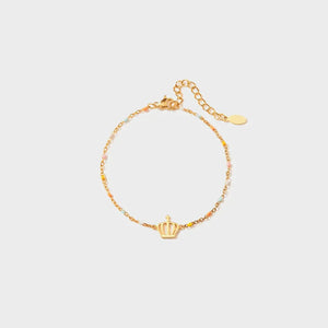 Gold bracelet with colorful enamel beads and a crown charm.