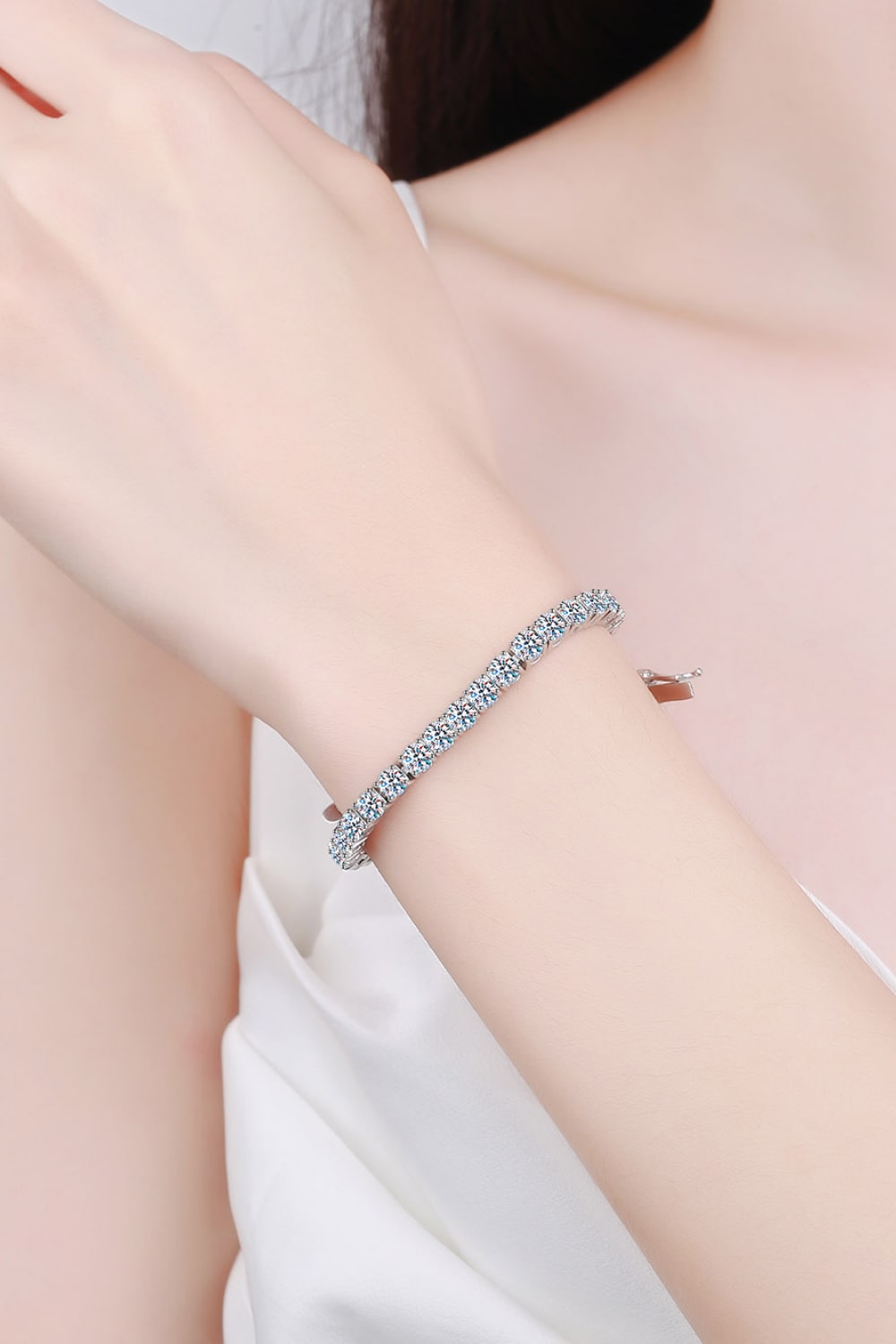 Silver diamond tennis bracelet with a delicate chain and sparkling stones.